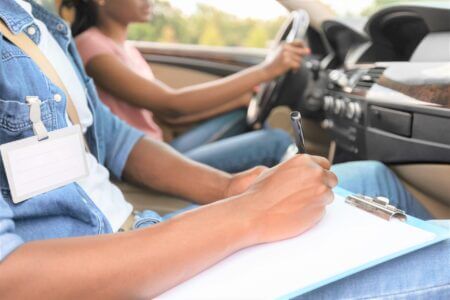 driving-instructor-writing-down-results-of-exam-d-2021-12-09-07-40-20-scaled-450x300