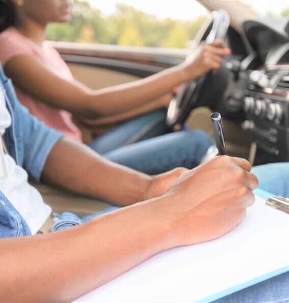 driving-instructor-writing-down-results-of-exam-d-2021-12-09-07-40-20-scaled-567x594